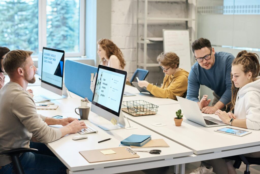 Woman with headset working on laptop in bright office environment